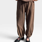 JONES + CO chocolate brown heavy cotton balloon pants with elastic cuffs and side pockets on a model