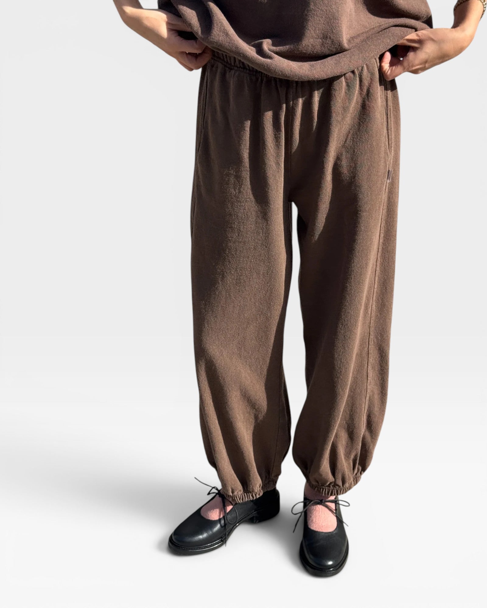 JONES + CO chocolate brown heavy cotton balloon pants with elastic cuffs and side pockets on a model
