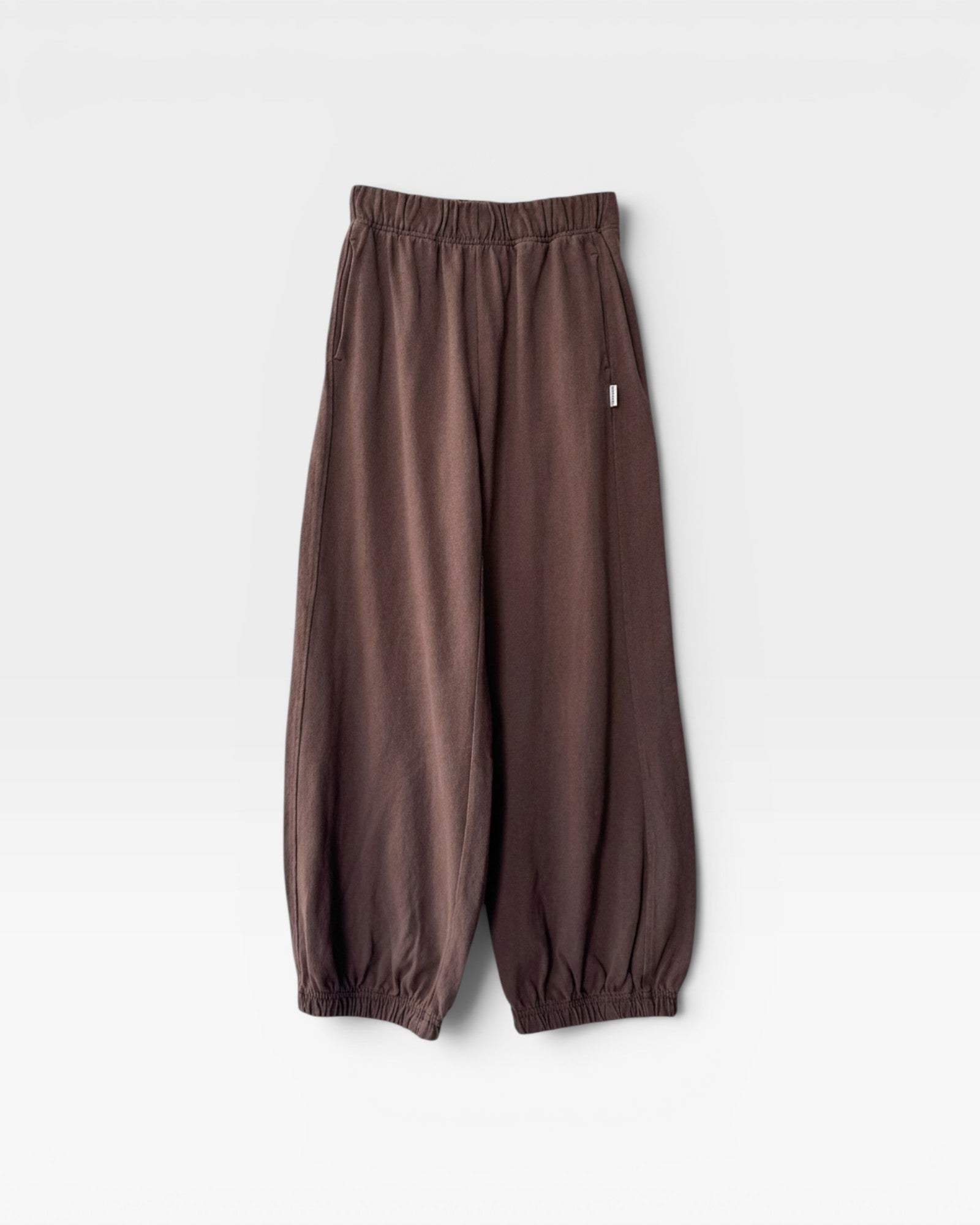 JONES + CO chocolate brown heavy cotton balloon pants with elastic cuffs and side pockets on a white background.