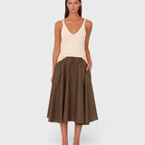 Model wearing a JONES + CO chocolate brown cotton poplin midi skirt with side pockets and a drawstring waistband.