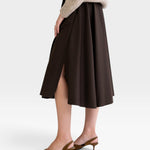 JONES + CO chocolate brown midi skirt with side slits and pockets, paired with a beige sweater and brown heels.