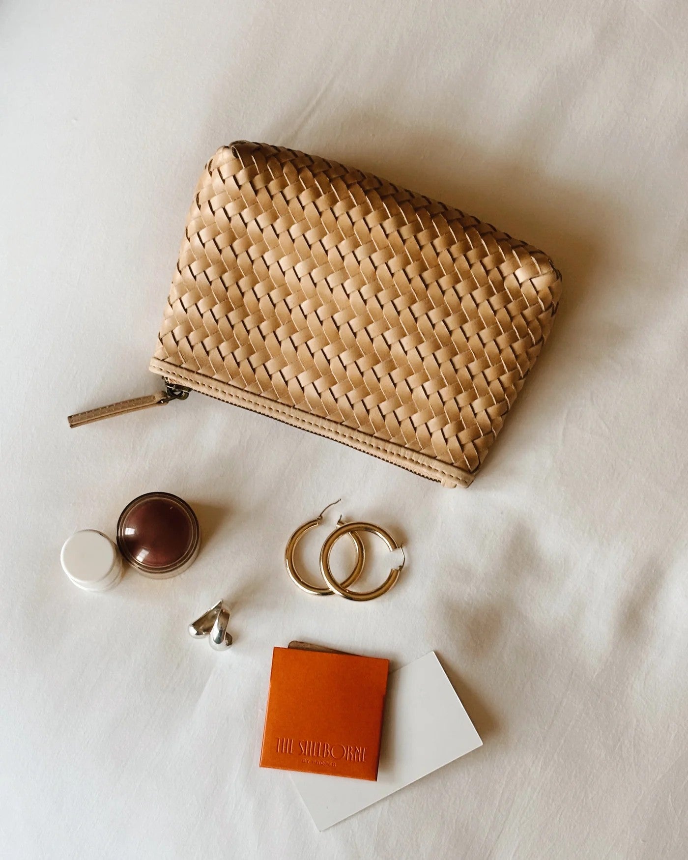 JONES + CO Cleo Pouch in woven tan leather. Zip closure. Perfect for organizing essentials.