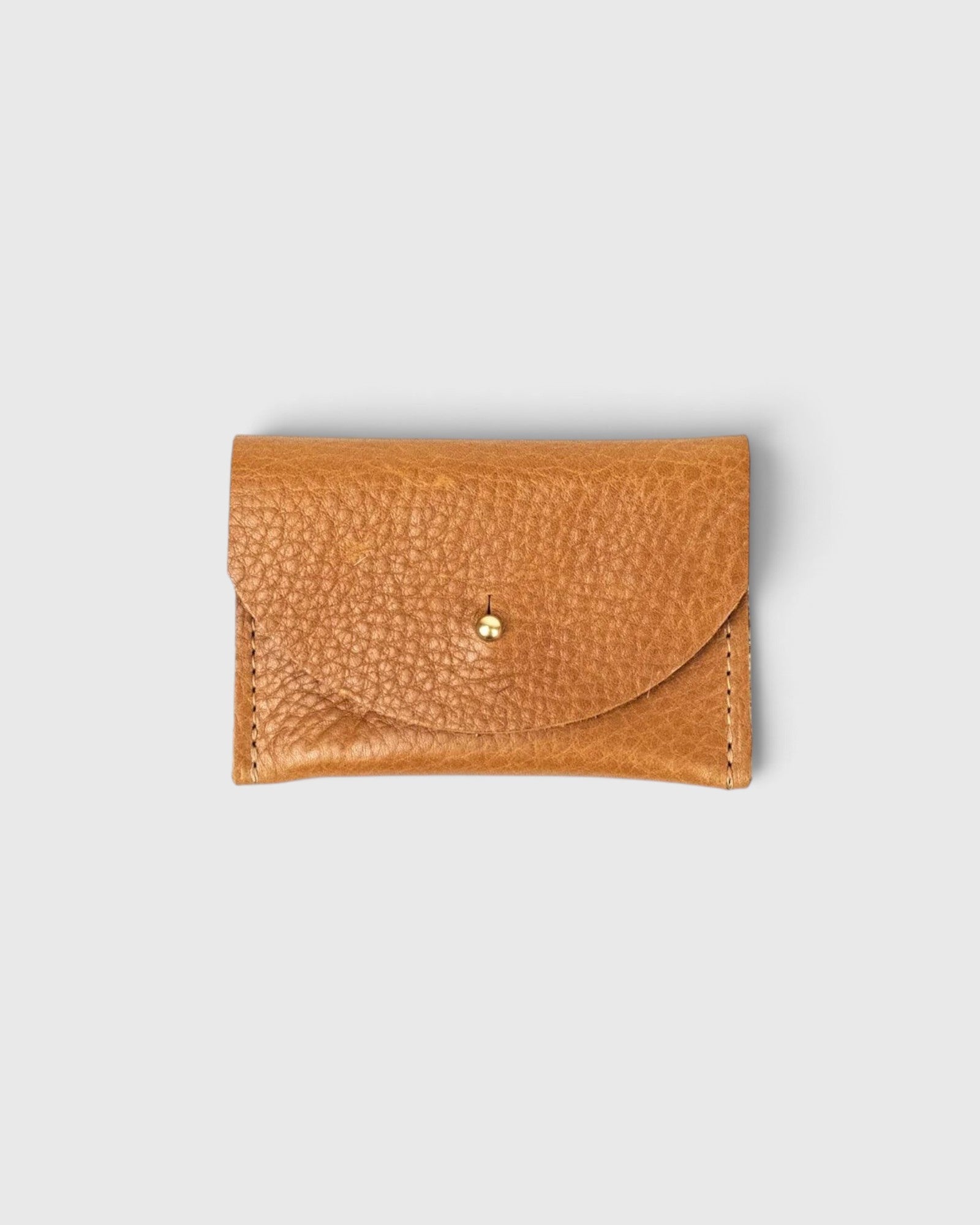 JONES + CO cognac leather cardholder with a pebbled texture and a simple brass stud closure.