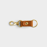 JONES + CO cognac leather keychain with gold-tone metal clasp and ring on a light grey background