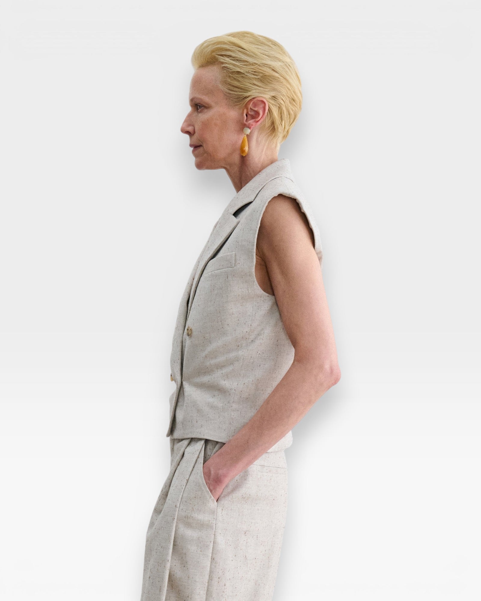JONES + CO Comeau grey speckled double-breasted vest with peak lapels worn by a model in profile view.