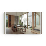 JONES + CO Courtyard Homes book open to a spread showing a modern dining room with floor-to-ceiling windows and garden.