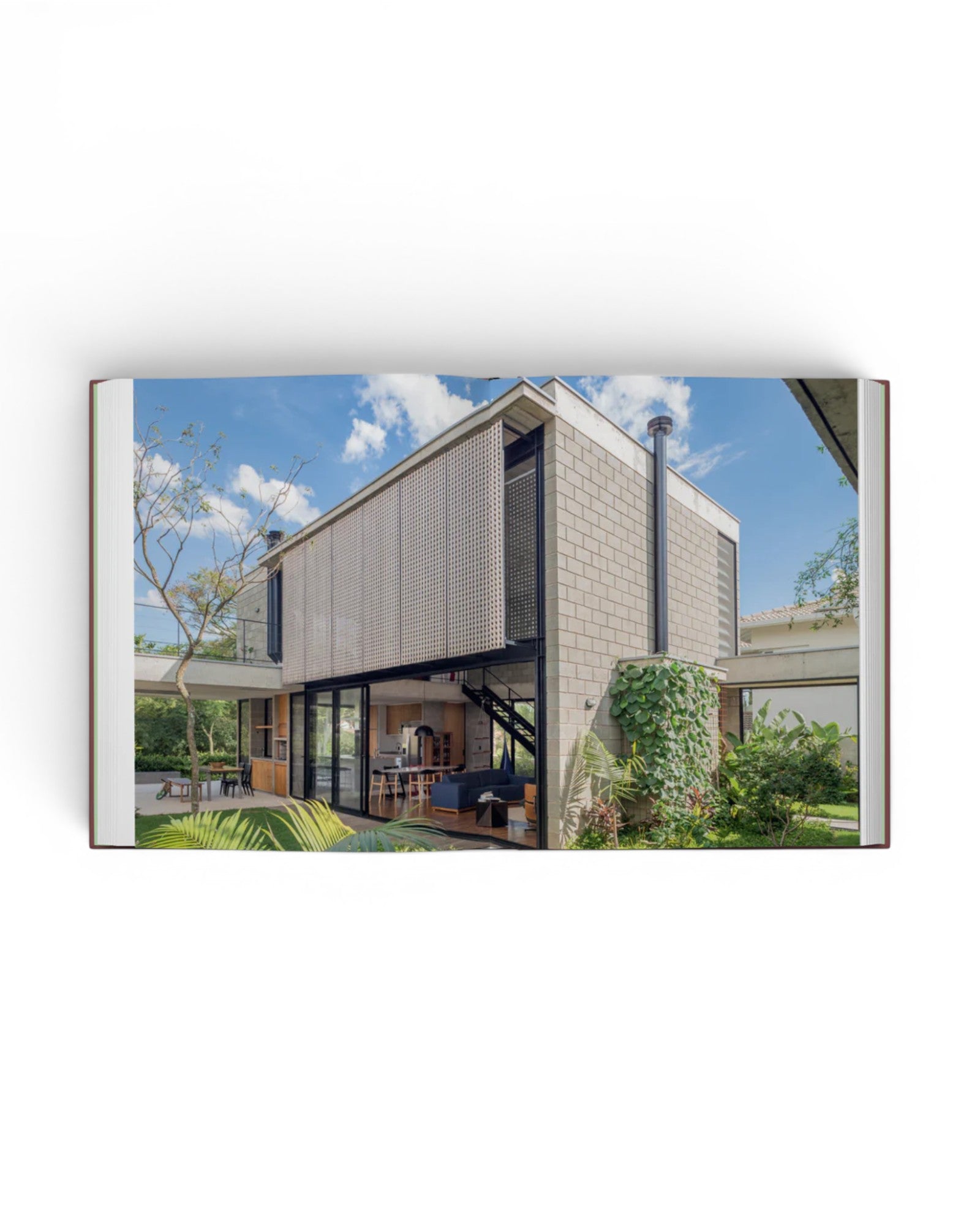 JONES + CO Courtyard Homes book open to a photograph of a modern concrete house with a lush garden courtyard.