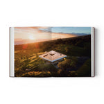 JONES + CO Courtyard Homes book open to a page showing an aerial view of a triangular modern home at sunset.