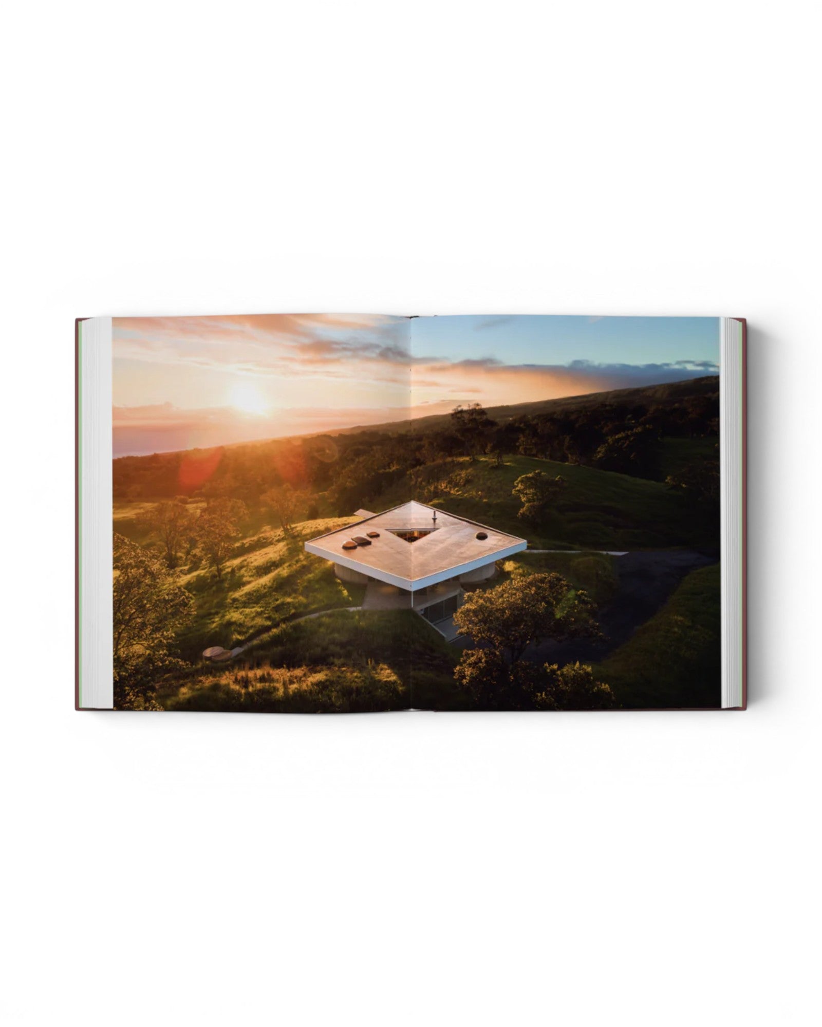 JONES + CO Courtyard Homes book open to a page showing an aerial view of a triangular modern home at sunset.