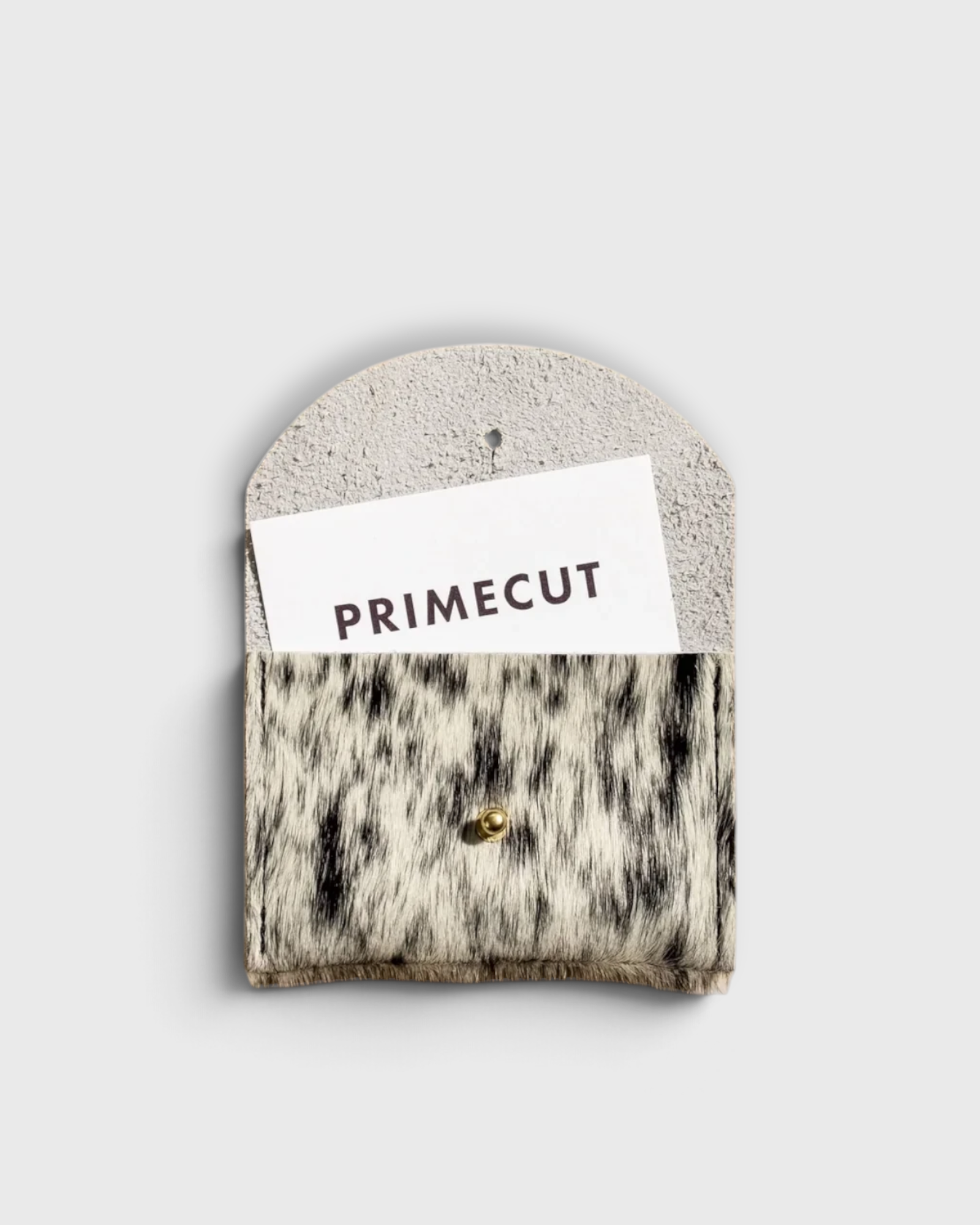 JONES + CO salt and pepper cowhide cardholder with a gold snap closure on a neutral background