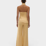 JONES + CO Syna wide-leg linen pants in daffodil yellow worn with a matching halter top, back view.