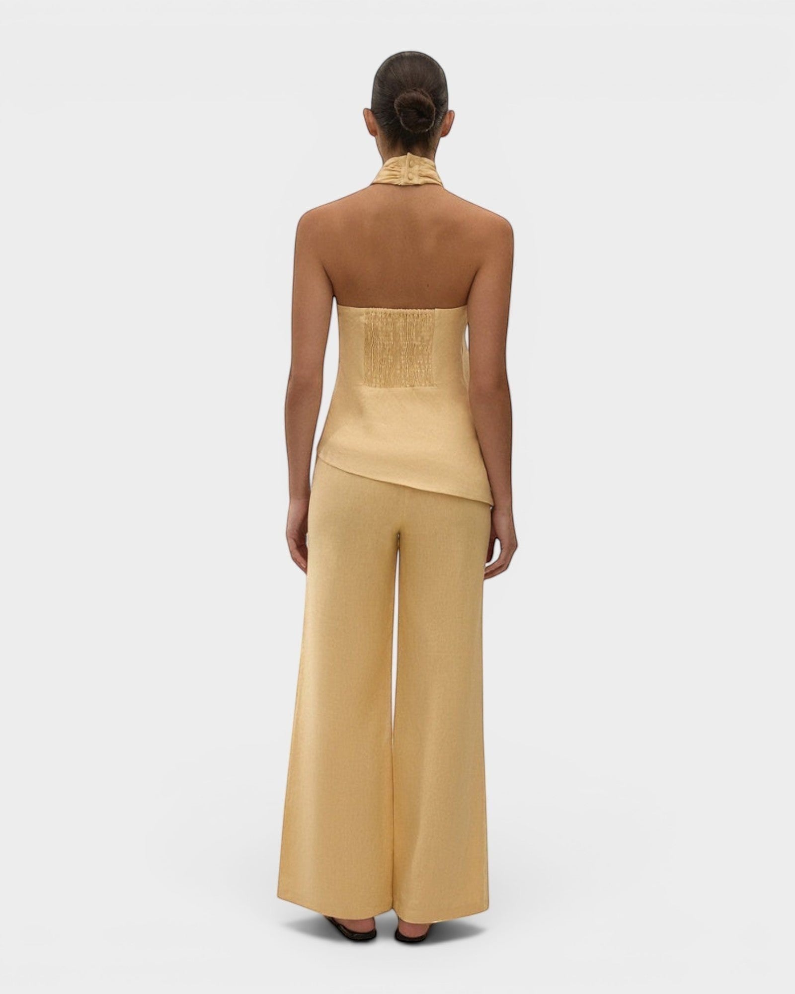 JONES + CO Syna wide-leg linen pants in daffodil yellow worn with a matching halter top, back view.