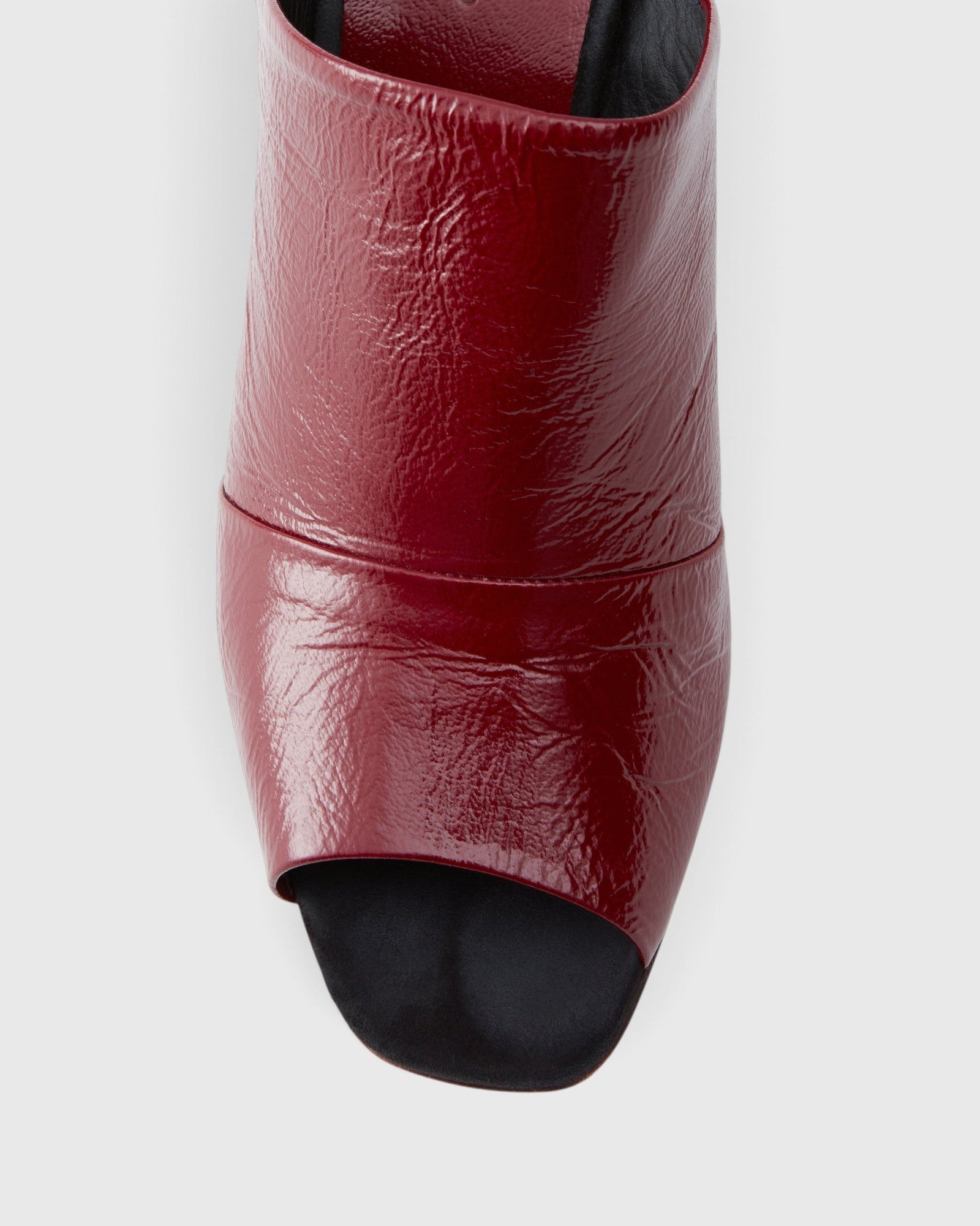 JONES + CO Dahl scarlet leather wedge mule with a sculptural silhouette and angular peep toe design.