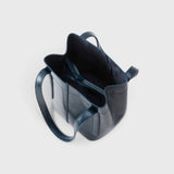 JONES + CO Bucket Tool bag in dark indigo lustre leather with vertical paneling and an open top interior tie closure.