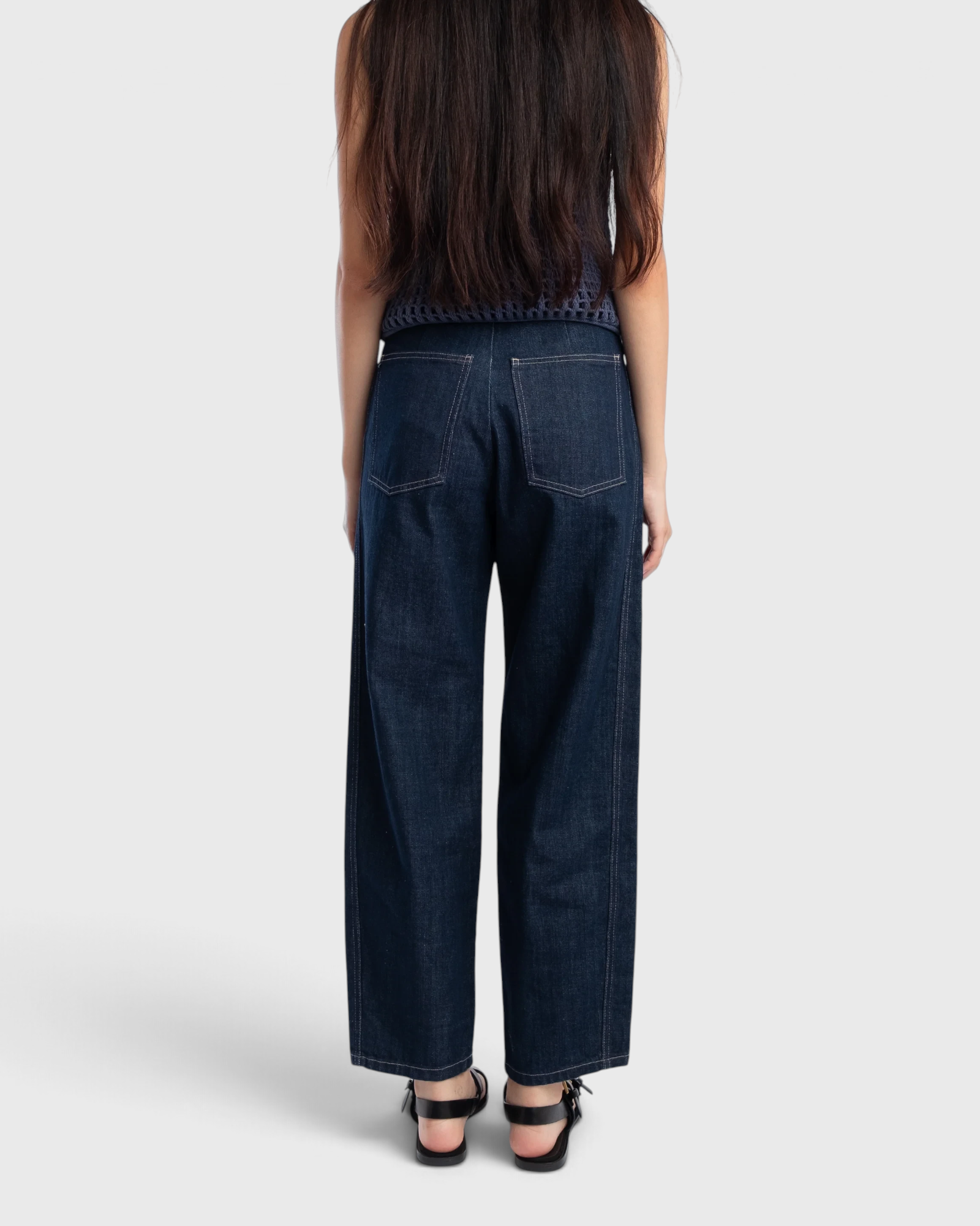 JONES + CO dark indigo high-rise relaxed-fit jeans with outseam piecing and rounded leg shape, back view
