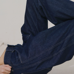 JONES + CO dark indigo high-rise relaxed-fit jeans with outseam piecing and a rounded leg shape