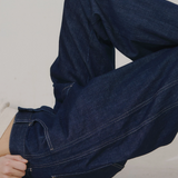JONES + CO dark indigo high-rise relaxed-fit jeans with outseam piecing and a rounded leg shape