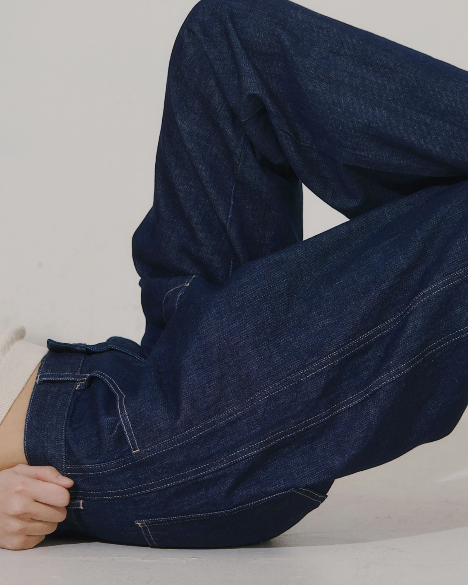 JONES + CO dark indigo high-rise relaxed-fit jeans with outseam piecing and a rounded leg shape