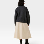 JONES + CO dark navy oversized shawl cardigan in alpaca and cotton blend, worn with a beige skirt and black boots.