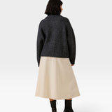JONES + CO dark navy oversized shawl cardigan in alpaca and cotton blend, worn with a beige skirt and black boots.