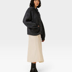 JONES + CO dark navy oversized shawl-collar cardigan in alpaca and cotton blend worn by a model with a cream skirt.