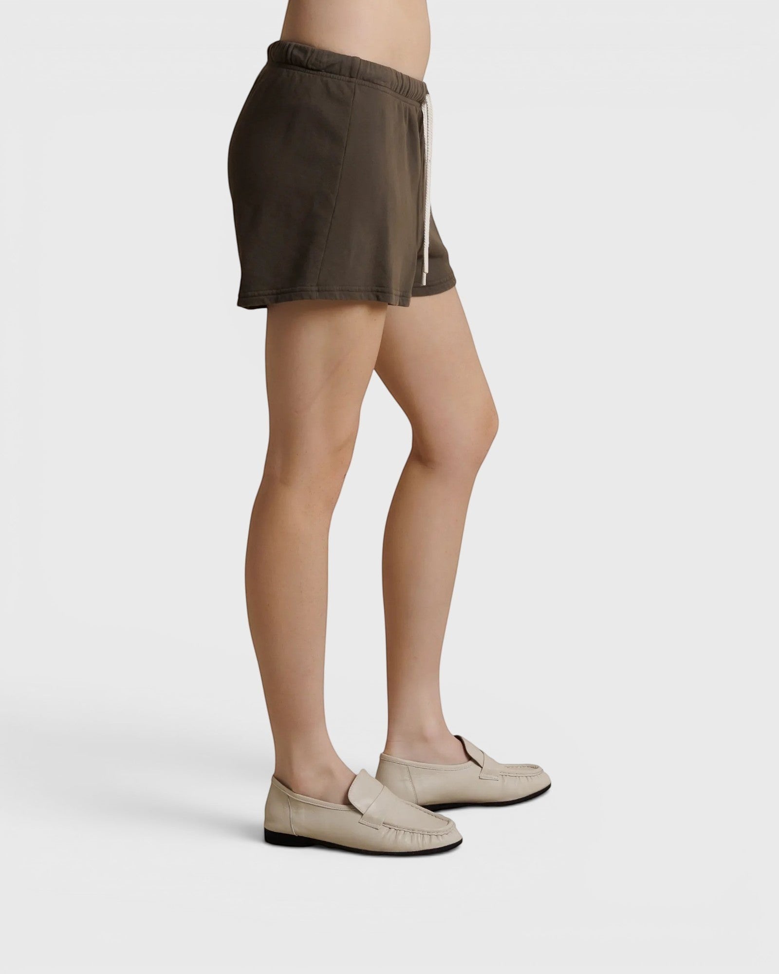 JONES + CO dark olive French terry lounge shorts with an elastic waistband, drawcord, and raw edge hem, side view.