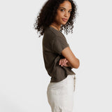 Model wearing a JONES + CO dark olive recycled cotton Alanis V-neck tee with a relaxed cropped fit