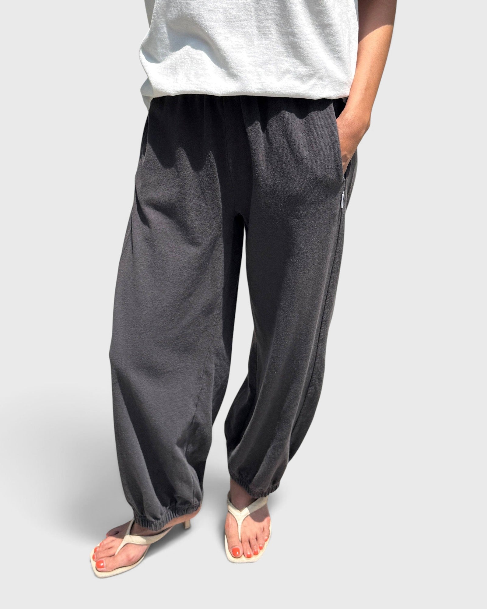 JONES + CO dark slate balloon pants with high elastic waist, side pockets, and gathered cuffs on a model