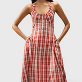 JONES + CO Del Rose midi dress in terra rosso check cotton with halterneck, front tie, and A-line skirt.
