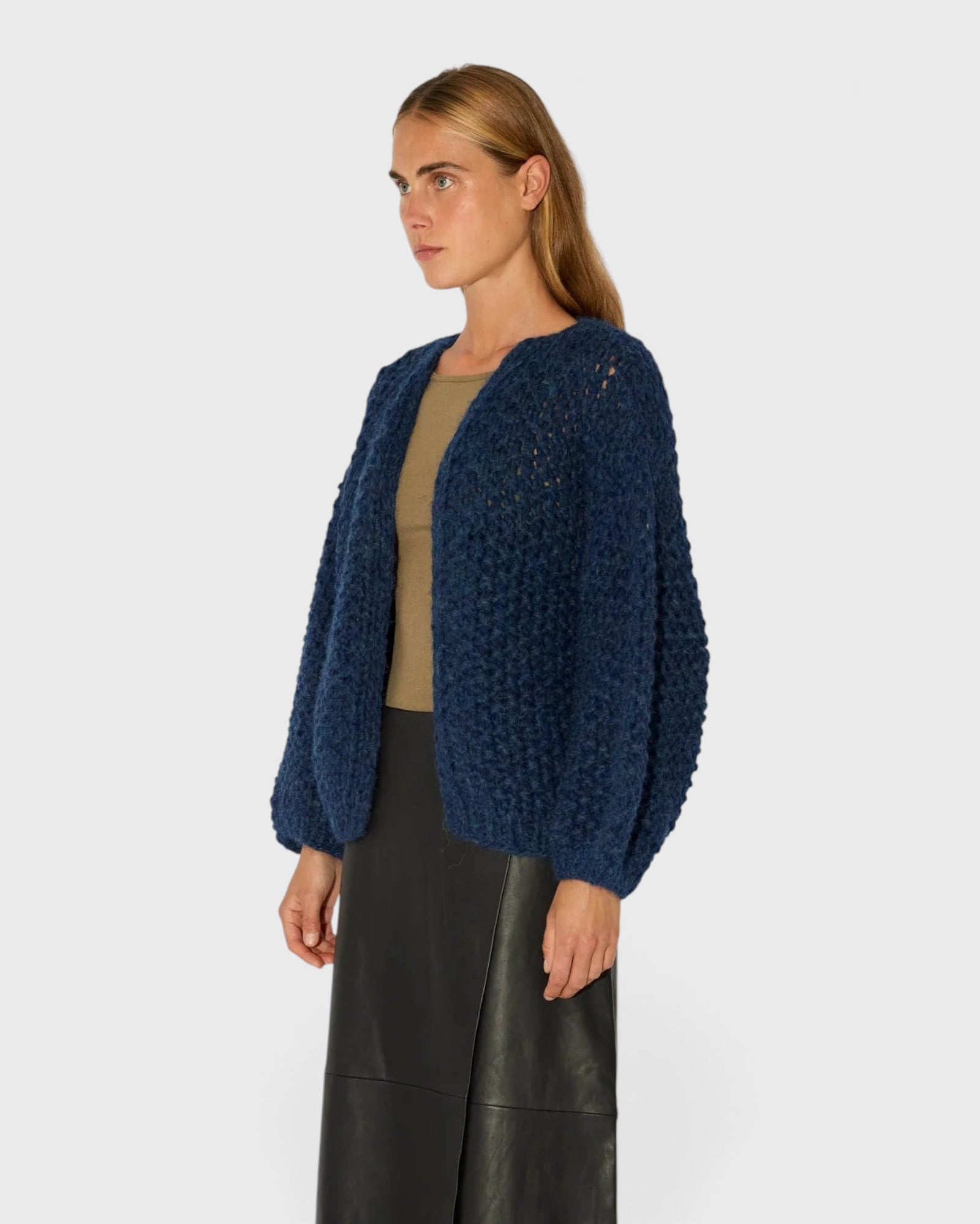 JONES + CO denim blue chunky alpaca bomber cardigan with a textured pearl knit pattern worn by a model.