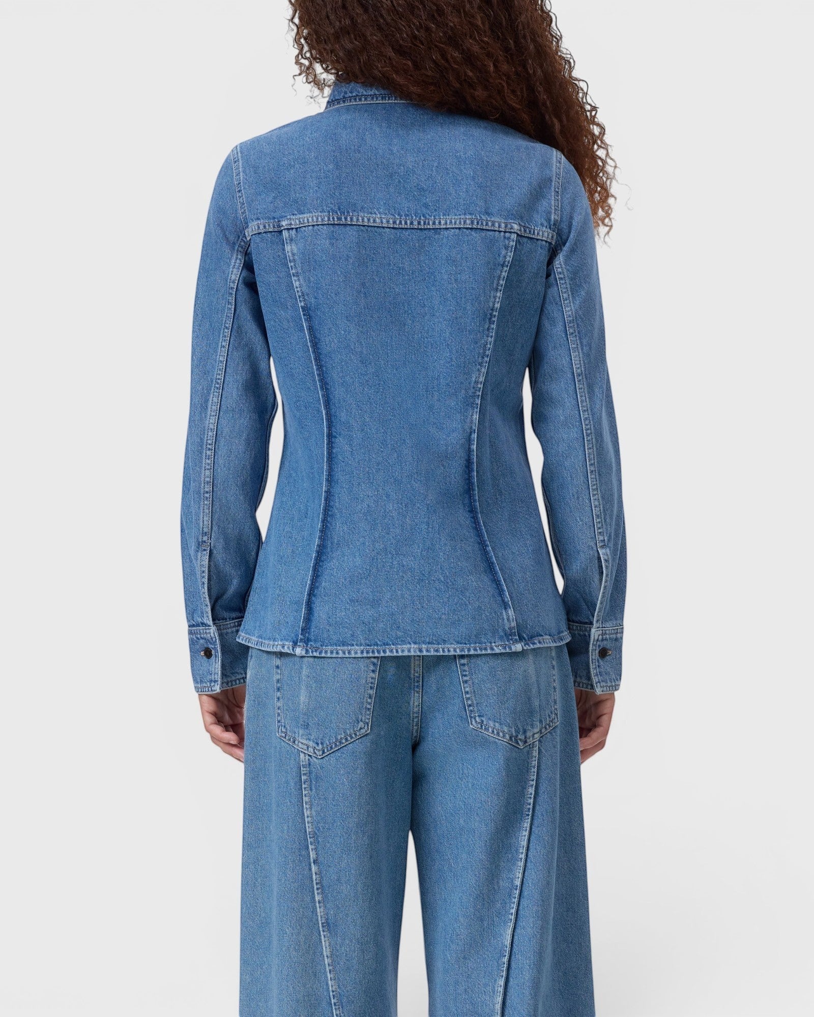 JONES + CO mid blue denim shirt with curved back seaming and long sleeves on a model