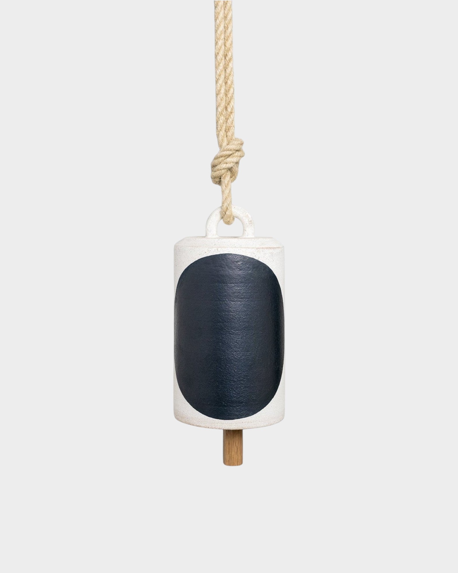 JONES + CO Thrown Bell in Domino Indigo featuring a white ceramic body with a large dark blue oval and rope hanger.