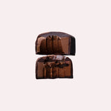 JONES + CO double chocolate truffle bar cut in half showing a smooth cacao centre with crunchy nibs and sea salt.