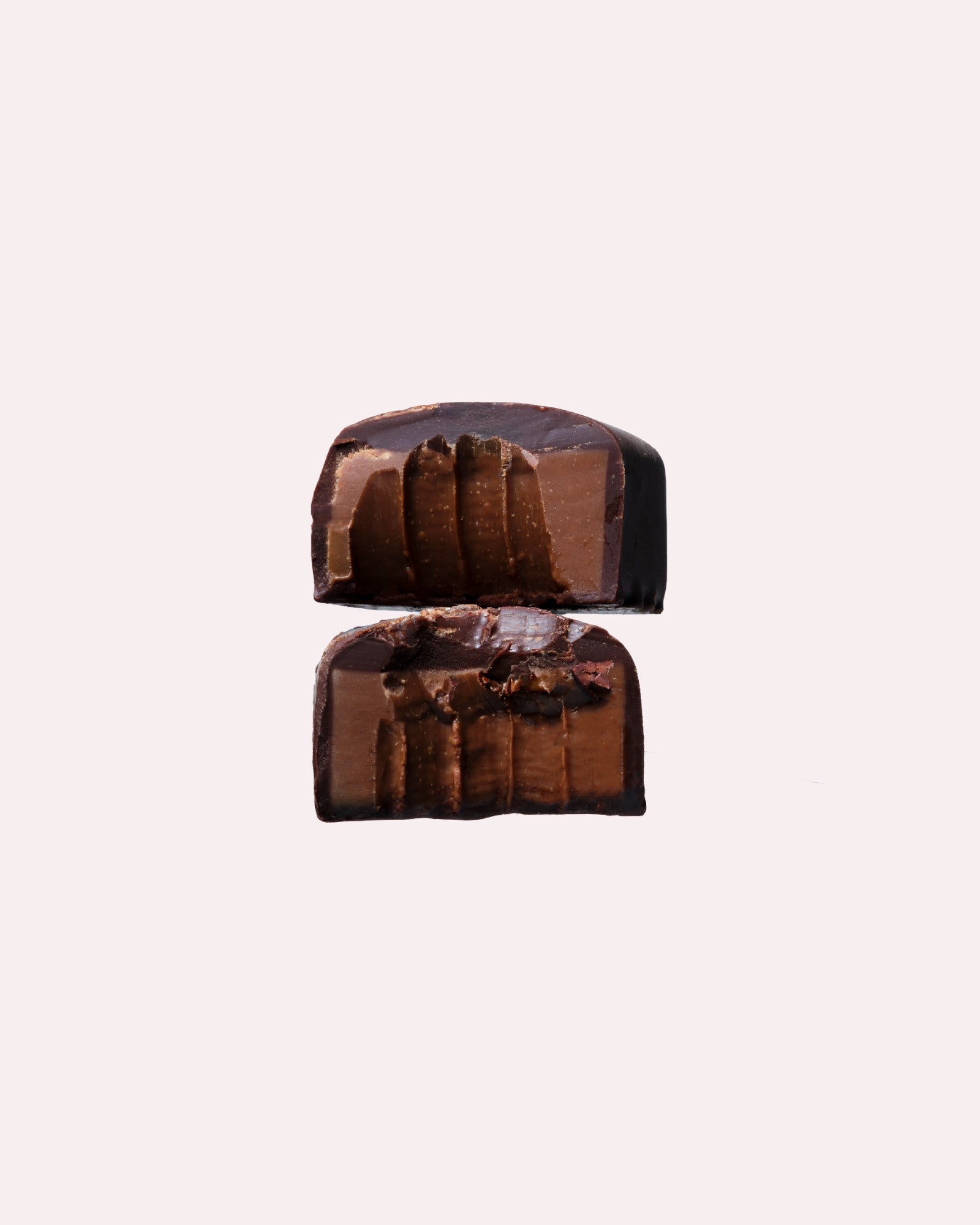 JONES + CO double chocolate truffle bar cut in half showing a smooth cacao centre with crunchy nibs and sea salt.