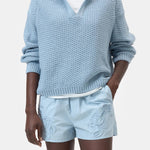 JONES + CO dove blue knitted jersey with 3D effect stripes and a V-neck. Organic cotton with ribbed cuffs.