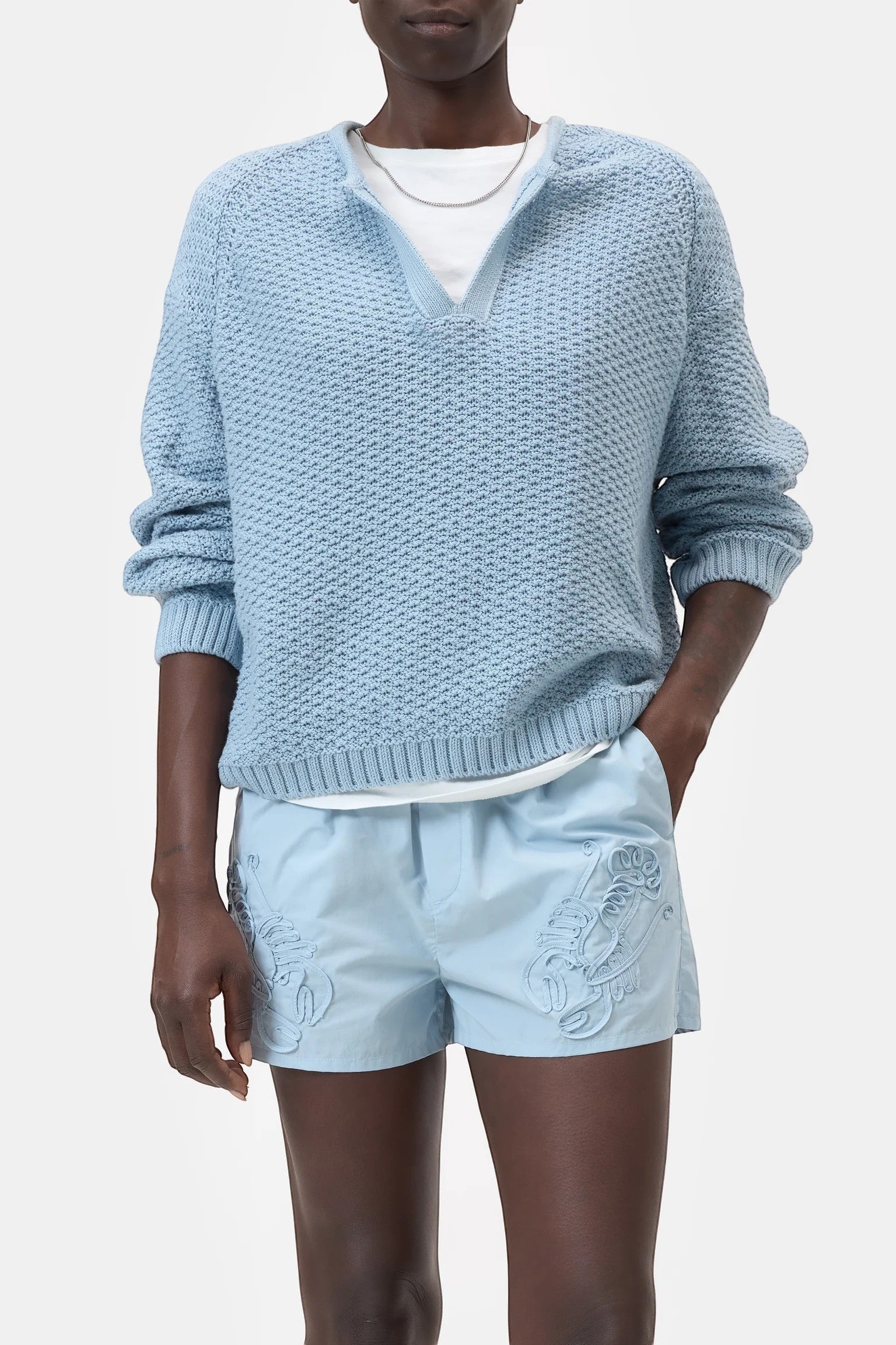 JONES + CO dove blue knitted jersey with 3D effect stripes and a V-neck. Organic cotton with ribbed cuffs.