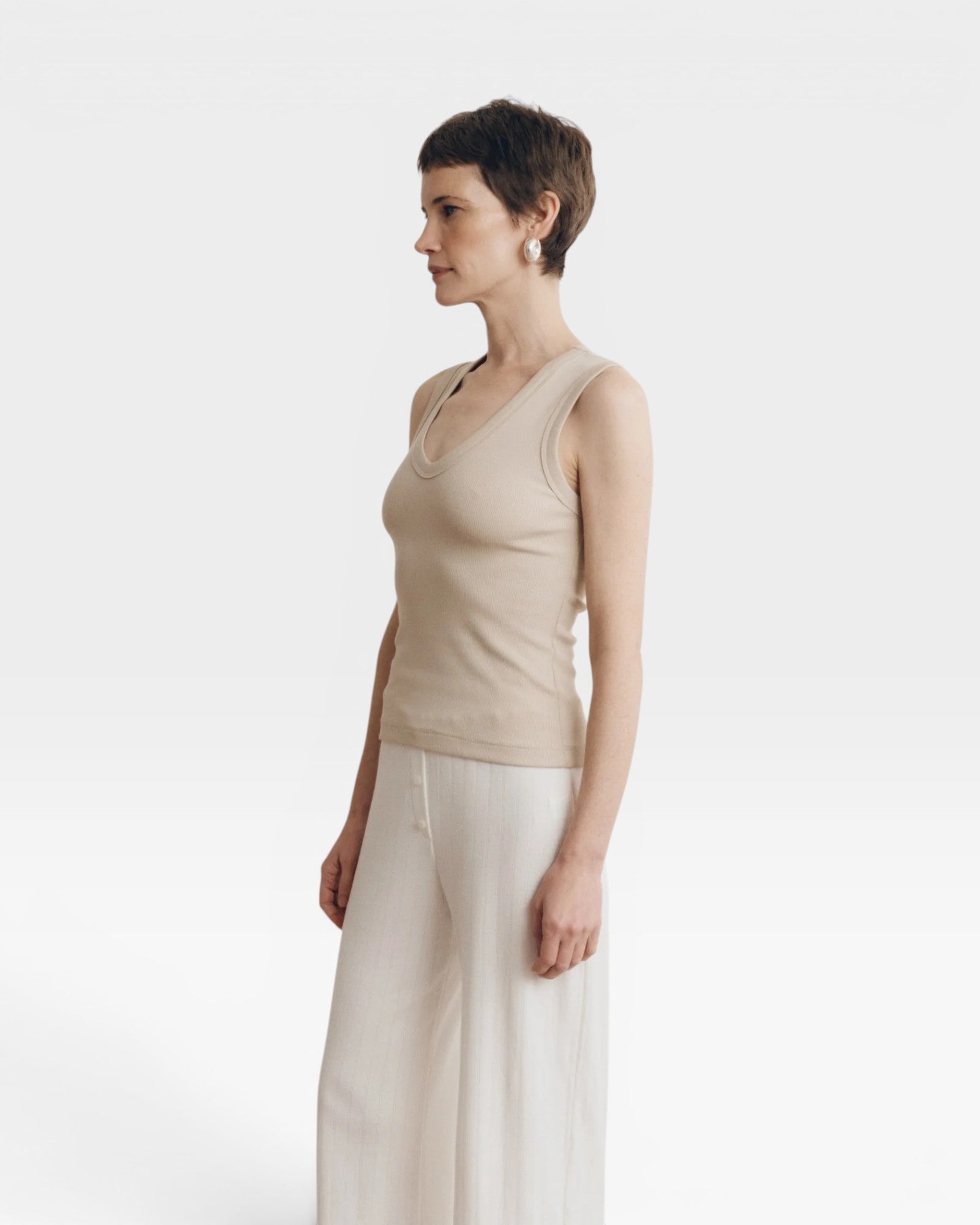 JONES + CO Dune ribbed knit tank top with a deep scoop neckline on a woman.