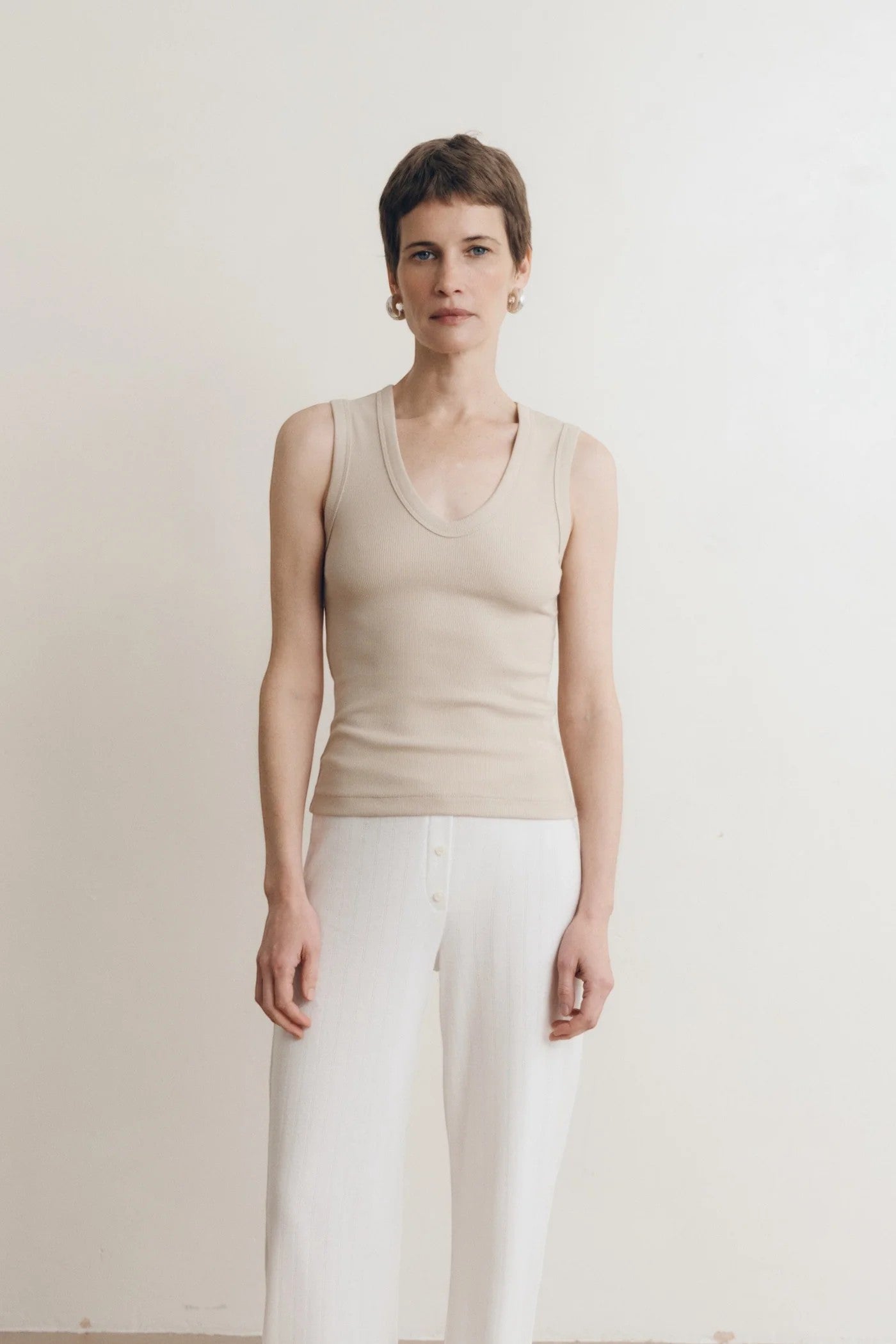 JONES + CO Dune ribbed knit tank top with deep scoop neckline on a woman.