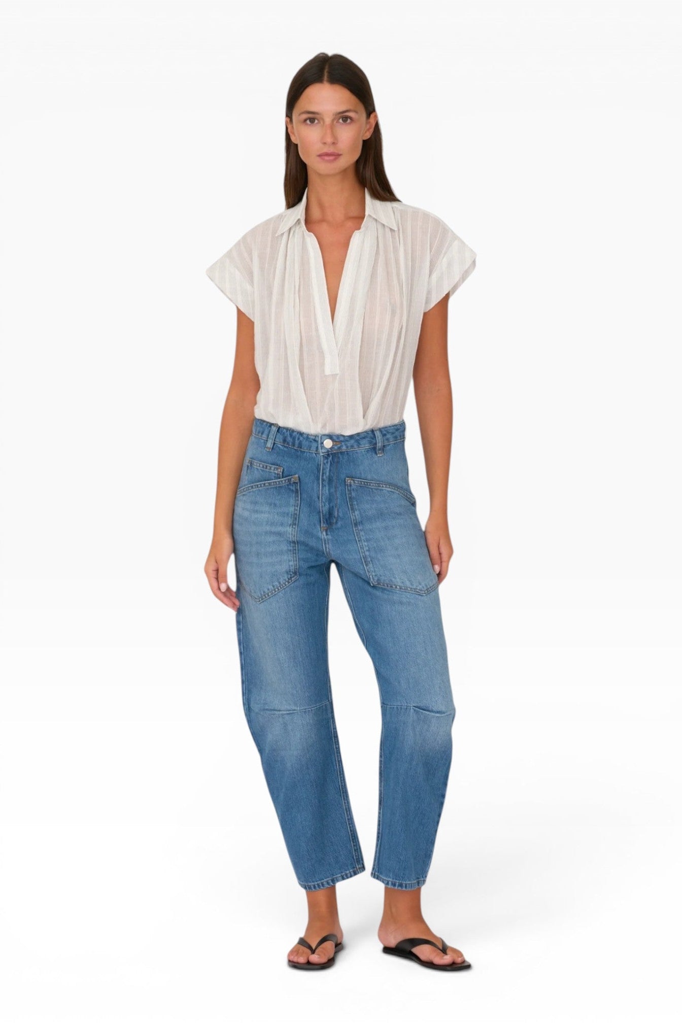 JONES + CO Easton Jean in Malibu Wash. Model wears blue denim jeans with large front pockets and a relaxed fit.