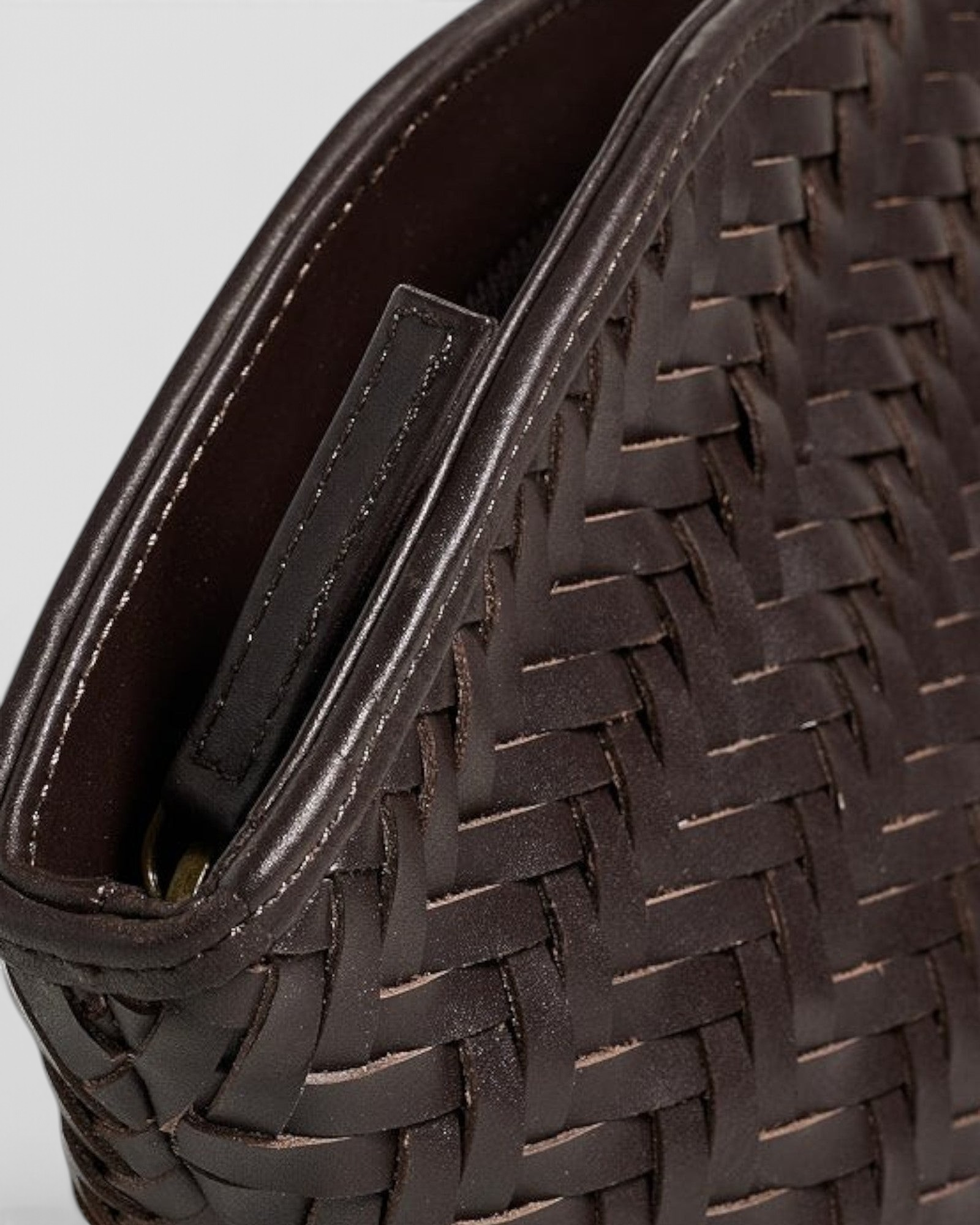 JONES + CO Elin Pouch in espresso brown braided calfskin leather with a zip closure and woven texture.