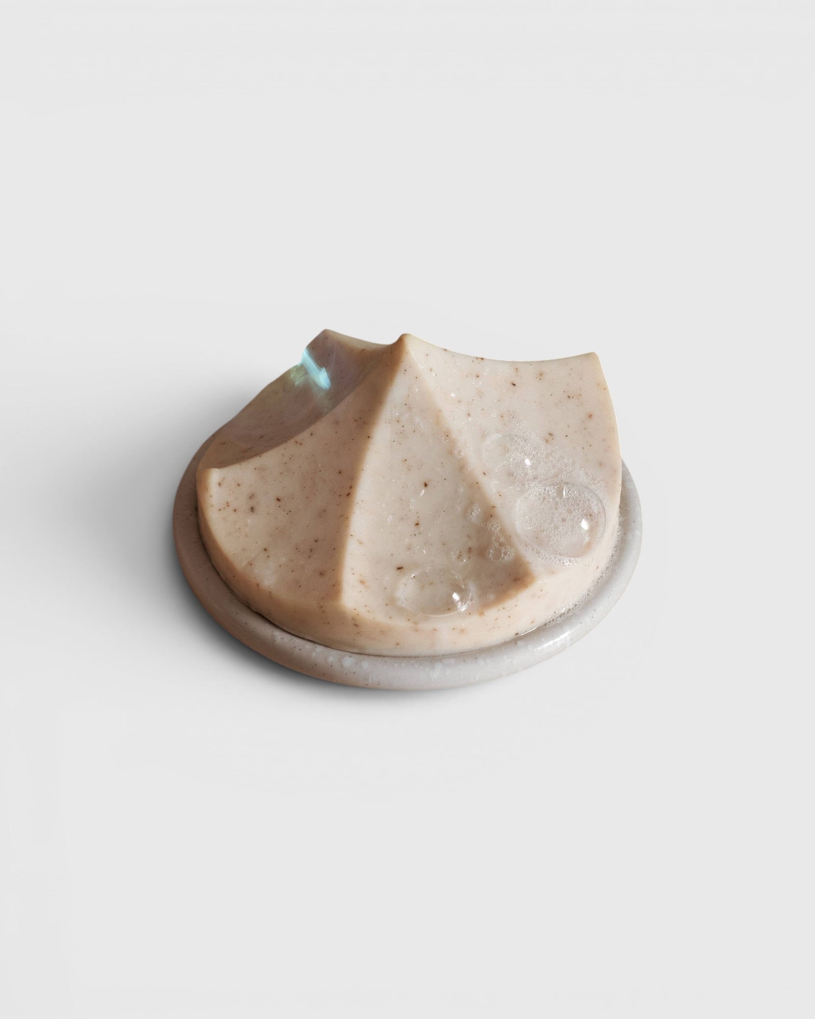 JONES + CO Erode Linden soap with chamomile and calendula on a round white ceramic dish