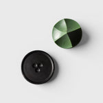 JONES + CO Erode Herbes de Provence soap in a geometric green shape next to a black ceramic Bouton soap dish.