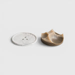 JONES + CO Erode soap in cardamom vetiver scent with a unique sculpted shape next to a white marble Bouton plate.