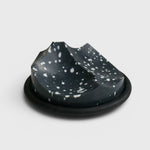 JONES + CO UME Studio Erode Soap Daily Detox in charcoal with white speckles on a black Bouton soap dish