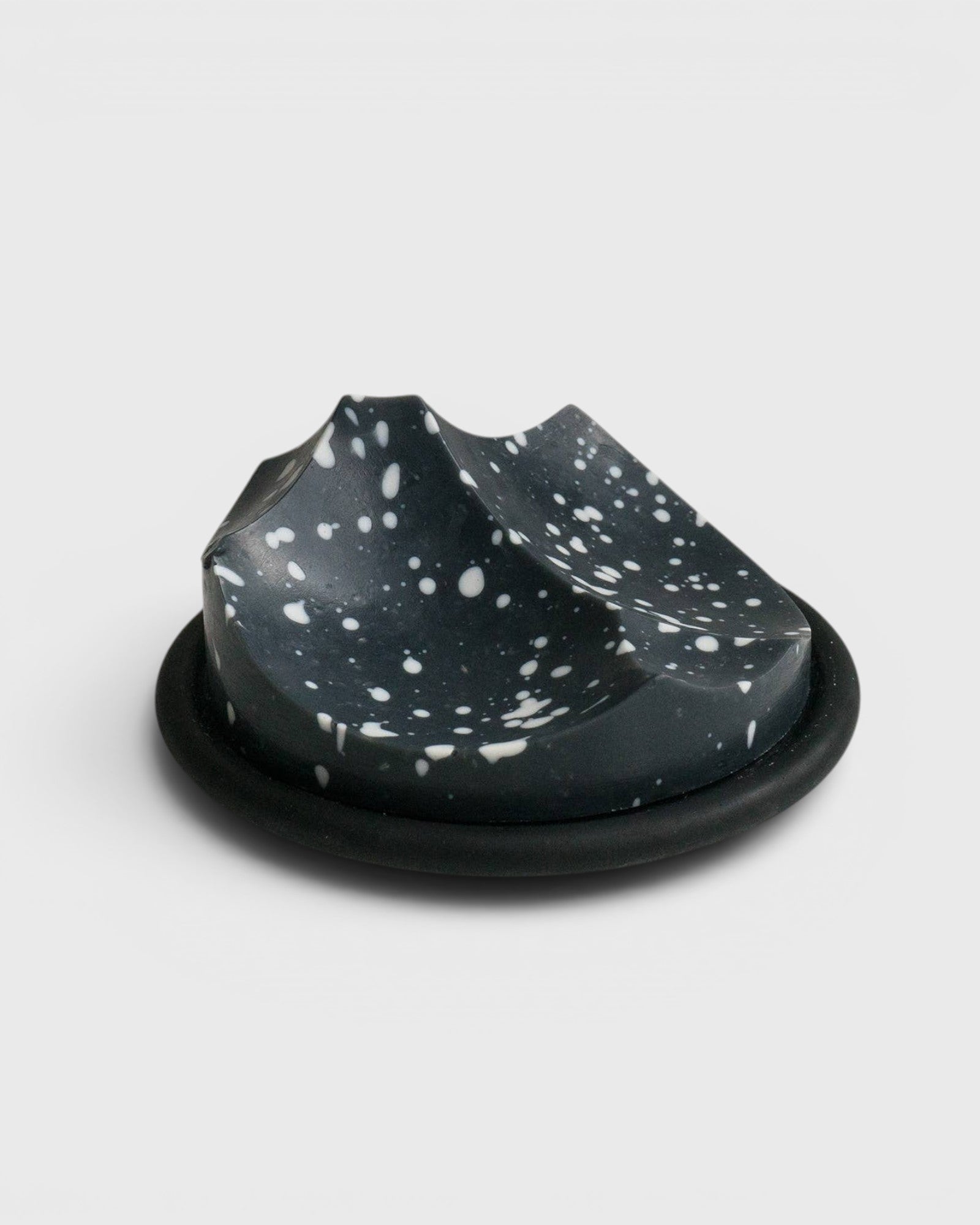 JONES + CO UME Studio Erode Soap Daily Detox in charcoal with white speckles on a black Bouton soap dish