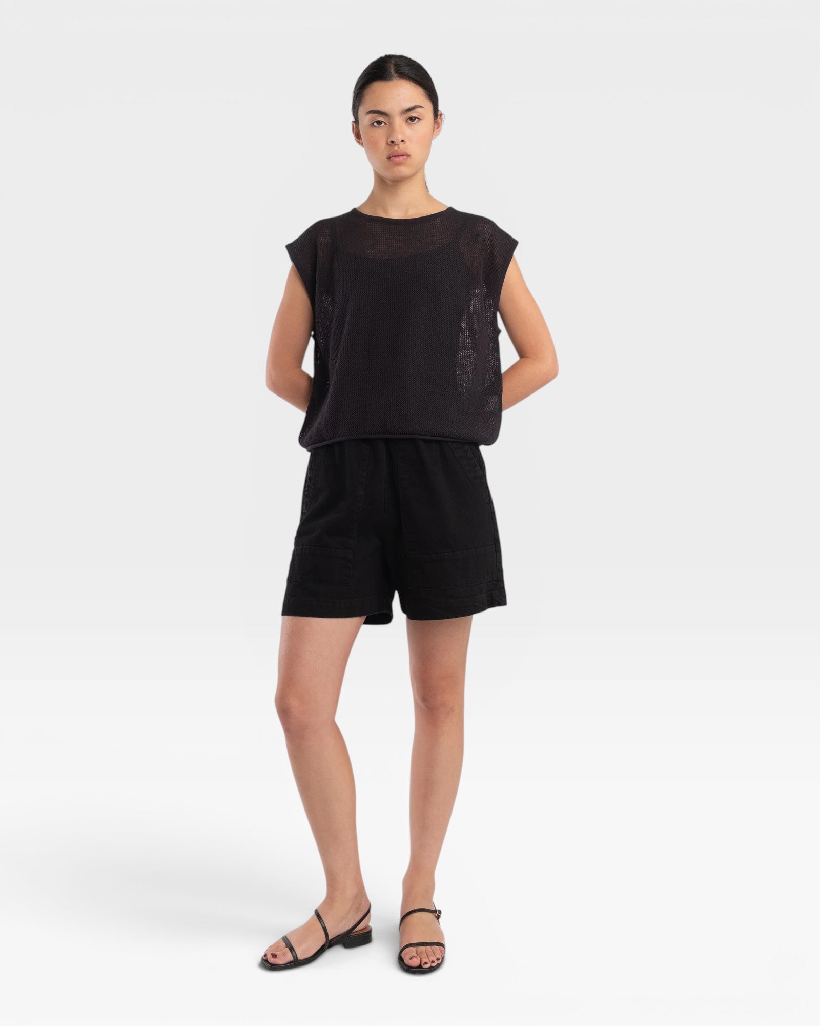 Model wearing a faded black JONES + CO fine mesh boxy tank top with refined trim details and matching black shorts.