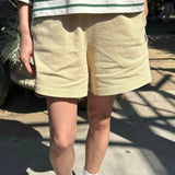 JONES + CO butter yellow 100% cotton flared basketball shorts with a textured knit and mid-thigh length.