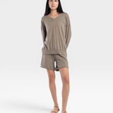 JONES + CO relaxed mid-length knit shorts in fog green with elastic waistband and drawstring. Model wears sandals.
