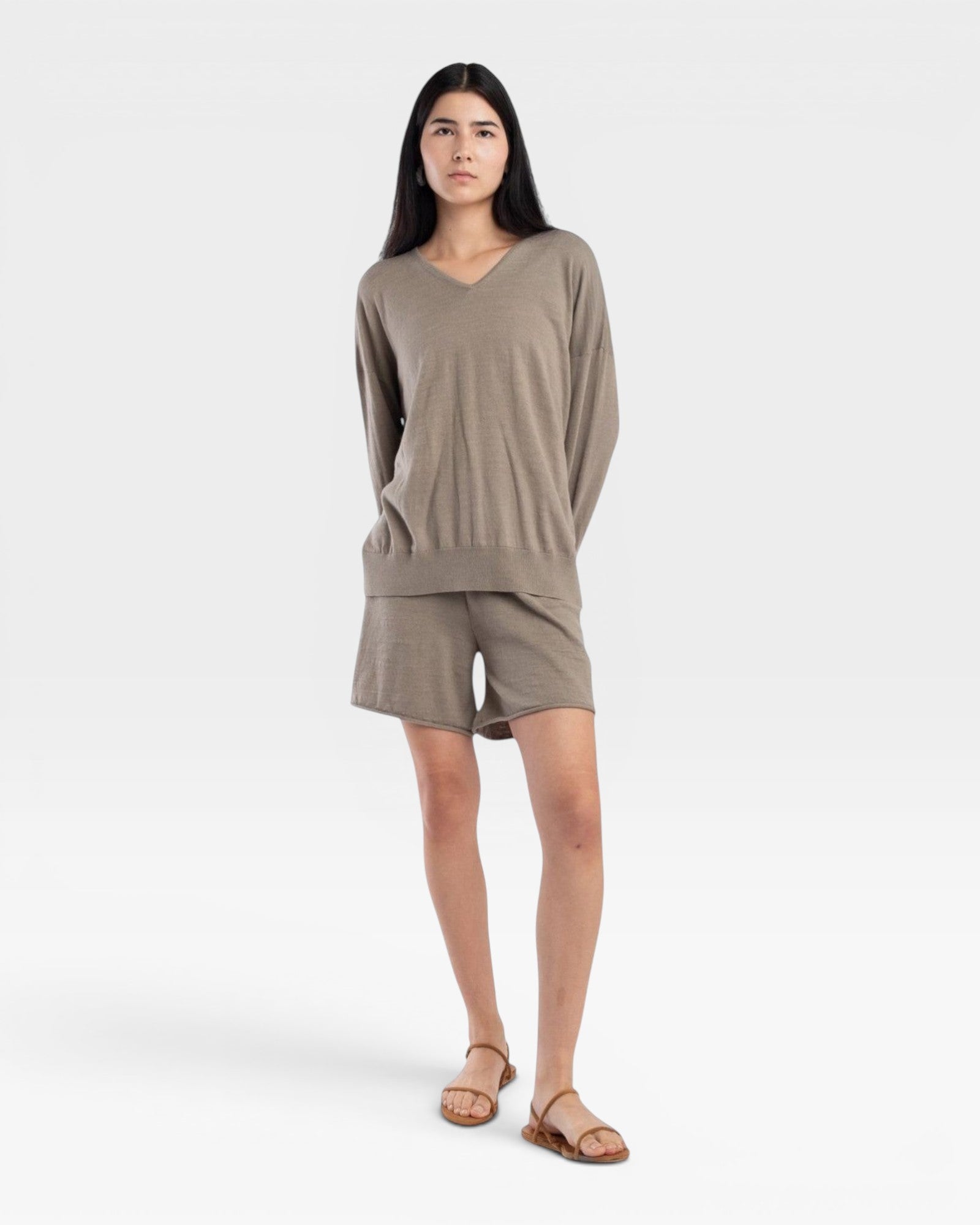 JONES + CO relaxed mid-length knit shorts in fog green with elastic waistband and drawstring. Model wears sandals.