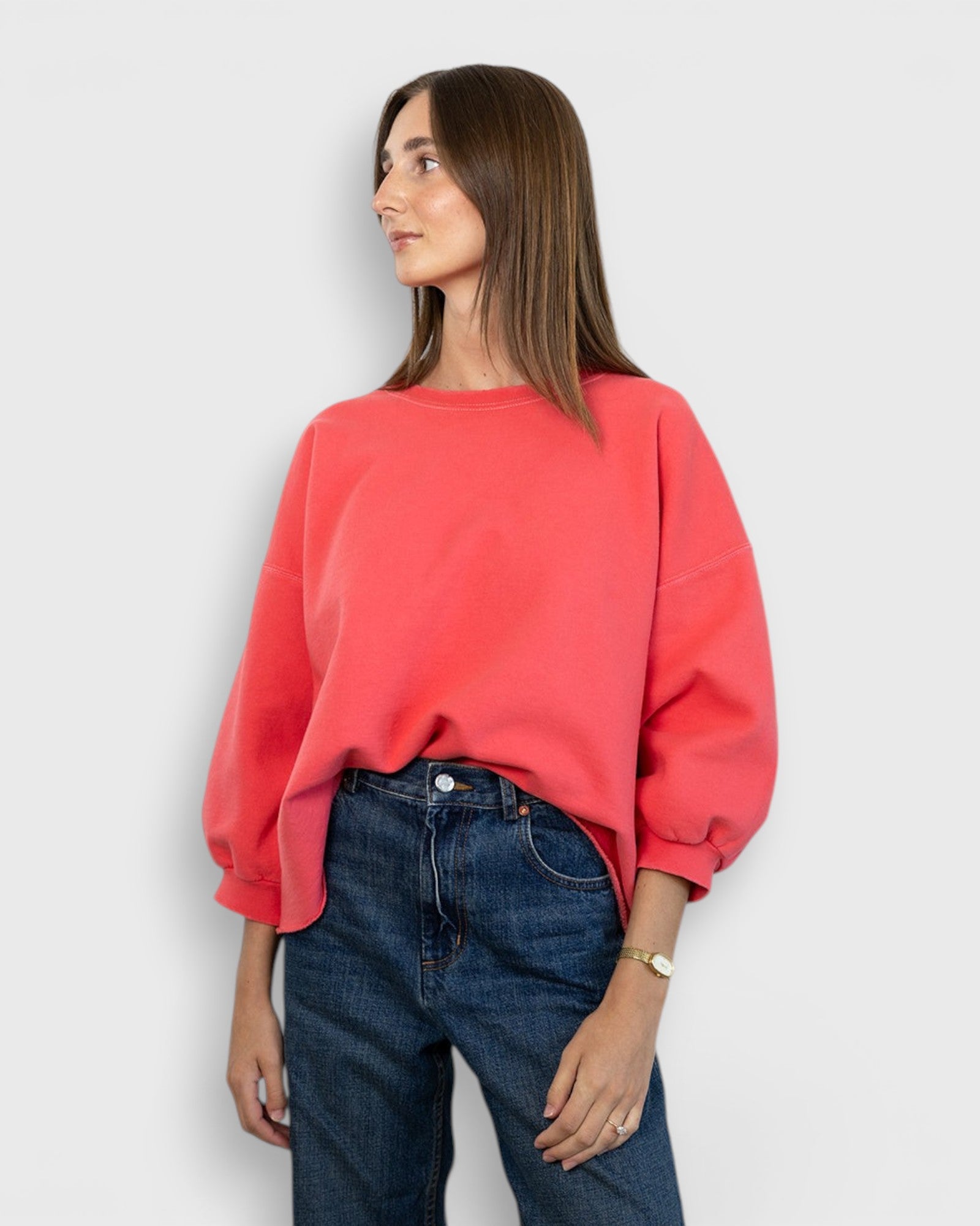 JONES + CO Fond crewneck sweatshirt in guava pink with drop shoulders and cropped sleeves on a model